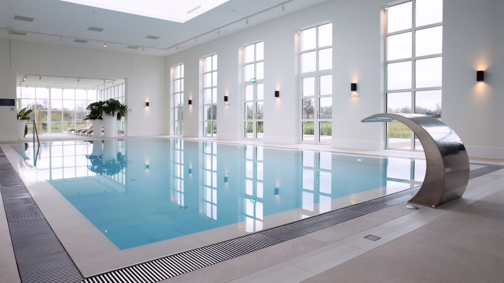 A large swimming pool with light grey tiles 