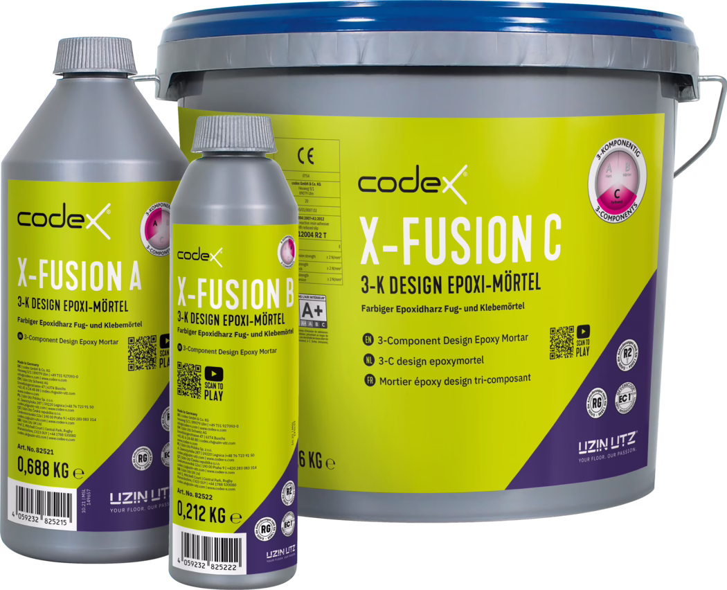 codex_Dummy_X-Fusion 3-C_front_2025-06 Tri označene posode Codex X-FUSION, 3-komponentnega dizajnerskega epoksi malta (X-FUSION A, B in C) na belem ozadju. Velik siv vedro z modrim pokrovom je označeno 'X-FUSION C' (6 kg), zraven pa sta dve manjši sivi steklenici z rumenimi etiketami 'X-FUSION A' (0,688 kg) in 'X-FUSION B' (0,212 kg). Embalaža vsebuje črno Codexovo logotip, kontrastne rumeno-vijolične etikete, tehnične podatke, ikone certifikatov in QR-kodo. Fotografija poudarja embalažo, označitve teže, navojne zamaške in kovinski ročaj vedra ter jasno tipografijo.